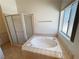 Serene bathroom featuring a corner shower, jacuzzi tub, and natural light from the window at 2080 Mount Charleston Dr, Pahrump, NV 89048