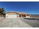 Single-story home with a two-car garage, desert landscaping, and beautiful mountain views in the distance at 2080 Mount Charleston Dr, Pahrump, NV 89048