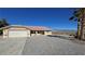 Desert home with a two-car garage, xeriscape yard, and desert views beyond a white fence at 2080 Mount Charleston Dr, Pahrump, NV 89048