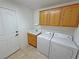 Well-lit laundry room with washer, dryer, sink and wood cabinets offers functional space at 2080 Mount Charleston Dr, Pahrump, NV 89048