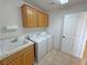 Functional laundry room with sink, wood cabinets, and modern washer and dryer at 2080 Mount Charleston Dr, Pahrump, NV 89048