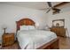 Bedroom with wood floors, ceiling fan, dresser, and a large bed at 2194 Camel Mesa Dr, Laughlin, NV 89029