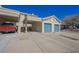 Home exterior featuring an attached garage with a blue door and covered parking at 2194 Camel Mesa Dr, Laughlin, NV 89029