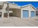 Home exterior featuring an attached garage with a blue door and covered parking at 2194 Camel Mesa Dr, Laughlin, NV 89029