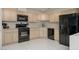 Functional kitchen featuring black appliances, light wood cabinetry, and tile flooring at 2194 Camel Mesa Dr, Laughlin, NV 89029