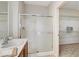 Bright bathroom featuring a glass-enclosed shower and a sink with wood vanity at 2204 Bay Thrush Way, North Las Vegas, NV 89084