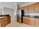 Bright kitchen featuring stainless steel appliances, wooden cabinets, dark countertop and tile flooring at 2204 Bay Thrush Way, North Las Vegas, NV 89084