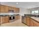 Bright kitchen features modern stainless steel appliances, tile floor, and light wood cabinets at 2204 Bay Thrush Way, North Las Vegas, NV 89084