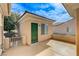 Outdoor patio area featuring a green side door, concrete flooring, and neutral-colored walls at 2204 Bay Thrush Way, North Las Vegas, NV 89084