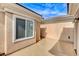 Outdoor patio with tan stucco walls, a large window, and concrete ground at 2204 Bay Thrush Way, North Las Vegas, NV 89084