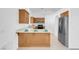 Bright kitchen area featuring wooden cabinets, stainless steel appliances and a breakfast bar at 240 Ember St, Pahrump, NV 89048