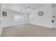 Spacious living room with plush carpet, a ceiling fan, and bright light from the window at 240 Ember St, Pahrump, NV 89048