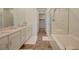 Modern bathroom featuring dual sinks, tile floor, a separate tub, and glass-enclosed shower at 25 Barbara Ln # 67, Las Vegas, NV 89183