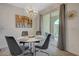 Elegant dining area featuring a modern chandelier, a round table with seating for four, and a sliding glass door at 25 Barbara Ln # 67, Las Vegas, NV 89183