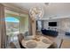 Elegant dining area featuring a modern chandelier, a round table with seating for four, and a sliding glass door at 25 Barbara Ln # 67, Las Vegas, NV 89183