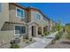 Inviting townhome exterior with stone accents, an arched entryway, and lush landscaping, creating a welcoming entrance at 25 Barbara Ln # 67, Las Vegas, NV 89183