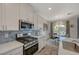 Modern kitchen with stainless steel appliances, white cabinetry, and blue tiled backsplash overlooking the dining area at 25 Barbara Ln # 67, Las Vegas, NV 89183