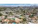 Wide aerial view of neighborhood homes with pools and mature trees, featuring cityscape in background at 2711 Ashby Ave, Las Vegas, NV 89102