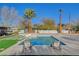Inviting backyard pool surrounded by stylish lounge chairs, lush grass, and swaying palm trees at 2711 Ashby Ave, Las Vegas, NV 89102