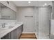 Modern bathroom featuring a double sink vanity, a glass enclosed shower with marble tile, and hardwood floors at 2711 Ashby Ave, Las Vegas, NV 89102