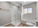 Modern bathroom features a glass enclosed shower with marble walls, a bathtub, and tiled floors at 2711 Ashby Ave, Las Vegas, NV 89102