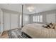 Light bedroom featuring hardwood floors, a comfortable bed, a ceiling light, and windows with white shutters at 2711 Ashby Ave, Las Vegas, NV 89102