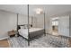 Bedroom featuring a four-poster bed, modern rug, and a door leading to another room at 2711 Ashby Ave, Las Vegas, NV 89102