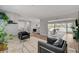 Open-concept living room featuring wood floors, large windows and comfortable seating at 2711 Ashby Ave, Las Vegas, NV 89102