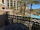 Cozy balcony with a table and chairs overlooking the community pool and palm trees at 29 Montelago # 108, Henderson, NV 89155