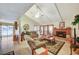 Bright living room featuring a vaulted ceiling, a cozy fireplace, and large windows, creating a comfortable and inviting space at 2974 Lindell Rd, Las Vegas, NV 89146