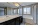 Bright bathroom featuring double sink vanity, soaking tub and glass enclosed shower at 3026 Coveri Ct, Las Vegas, NV 89141