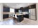 Modern kitchen with dark cabinets, stainless steel appliances, and a granite countertop island with seating at 3026 Coveri Ct, Las Vegas, NV 89141