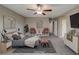 Relaxing main bedroom featuring a ceiling fan, a cozy sitting area and neutral decor at 3026 Coveri Ct, Las Vegas, NV 89141