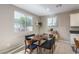 Charming dining area featuring a wooden table, seating for four, and natural light from two windows at 3034 Scenic Rhyme Ave, Henderson, NV 89044