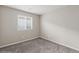 An empty bedroom with a light-colored wall-to-wall carpet and a window at 356 Free Fall Ave, North Las Vegas, NV 89084