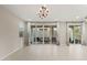 Spacious living room with tile flooring, a modern chandelier, and sliding glass doors to the patio at 356 Free Fall Ave, North Las Vegas, NV 89084