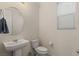 Modern powder room featuring a pedestal sink, toilet, window, and neutral wall paint at 356 Free Fall Ave, North Las Vegas, NV 89084