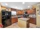 Traditional eat-in kitchen with wood cabinets, island, and stainless steel refrigerator at 3681 Via Sonja Ave, Las Vegas, NV 89115