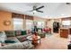 Open-concept living room featuring a comfortable sectional sofa, ceiling fan and natural light at 3681 Via Sonja Ave, Las Vegas, NV 89115