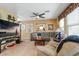 Relaxing living room with a comfortable sectional sofa, ceiling fan, and a wall-mounted television at 3681 Via Sonja Ave, Las Vegas, NV 89115