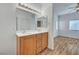 Bright bathroom with double sinks, wooden cabinets, and a large mirror offers a clean aesthetic at 4020 Smokey Fog Ave # 201, North Las Vegas, NV 89081