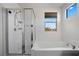 Bright and airy bathroom with soaking tub, glass-enclosed shower, and natural light from the window at 408 Gracious Way, Henderson, NV 89011