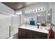 Well-lit bathroom with a double sink vanity, a large mirror, and a sleek glass-enclosed shower at 4446 Scarlet Sea Ave, North Las Vegas, NV 89031