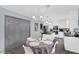 Open-concept kitchen and dining area featuring modern white cabinets, black countertops, and a dining table with seating at 4446 Scarlet Sea Ave, North Las Vegas, NV 89031