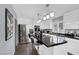 Bright kitchen with white cabinets, black granite countertops, stainless steel appliances, island with seating, and modern lighting at 4446 Scarlet Sea Ave, North Las Vegas, NV 89031