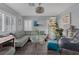 Cozy living room with sectional sofa, glass table, stylish decor, and abundant natural light through shuttered windows at 4446 Scarlet Sea Ave, North Las Vegas, NV 89031