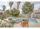 Backyard pool with spa and fire pit and mature landscaping for relaxing and outdoor enjoyment at 4446 Scarlet Sea Ave, North Las Vegas, NV 89031