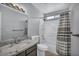 Well-lit bathroom features a granite-topped vanity and shower-over-tub with striped curtain at 4516 Whelk Pl, North Las Vegas, NV 89031