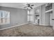 Bright bedroom with neutral carpet, arched windows, and a ceiling fan at 4516 Whelk Pl, North Las Vegas, NV 89031