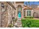 Charming home entrance with a bright blue front door and meticulously maintained landscaping at 4516 Whelk Pl, North Las Vegas, NV 89031